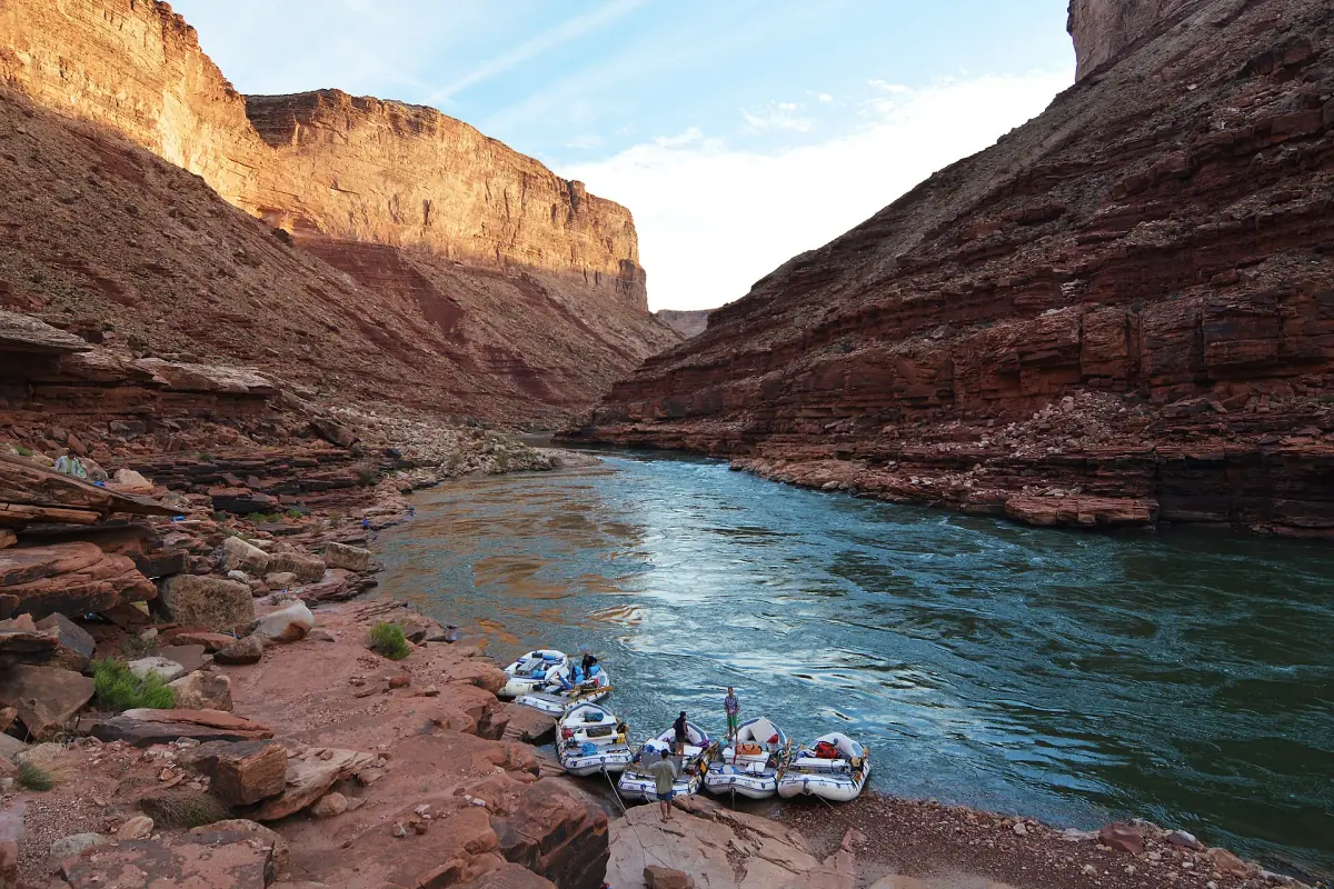 Rafts moored on the Colorado River beneath red canyon cliffs