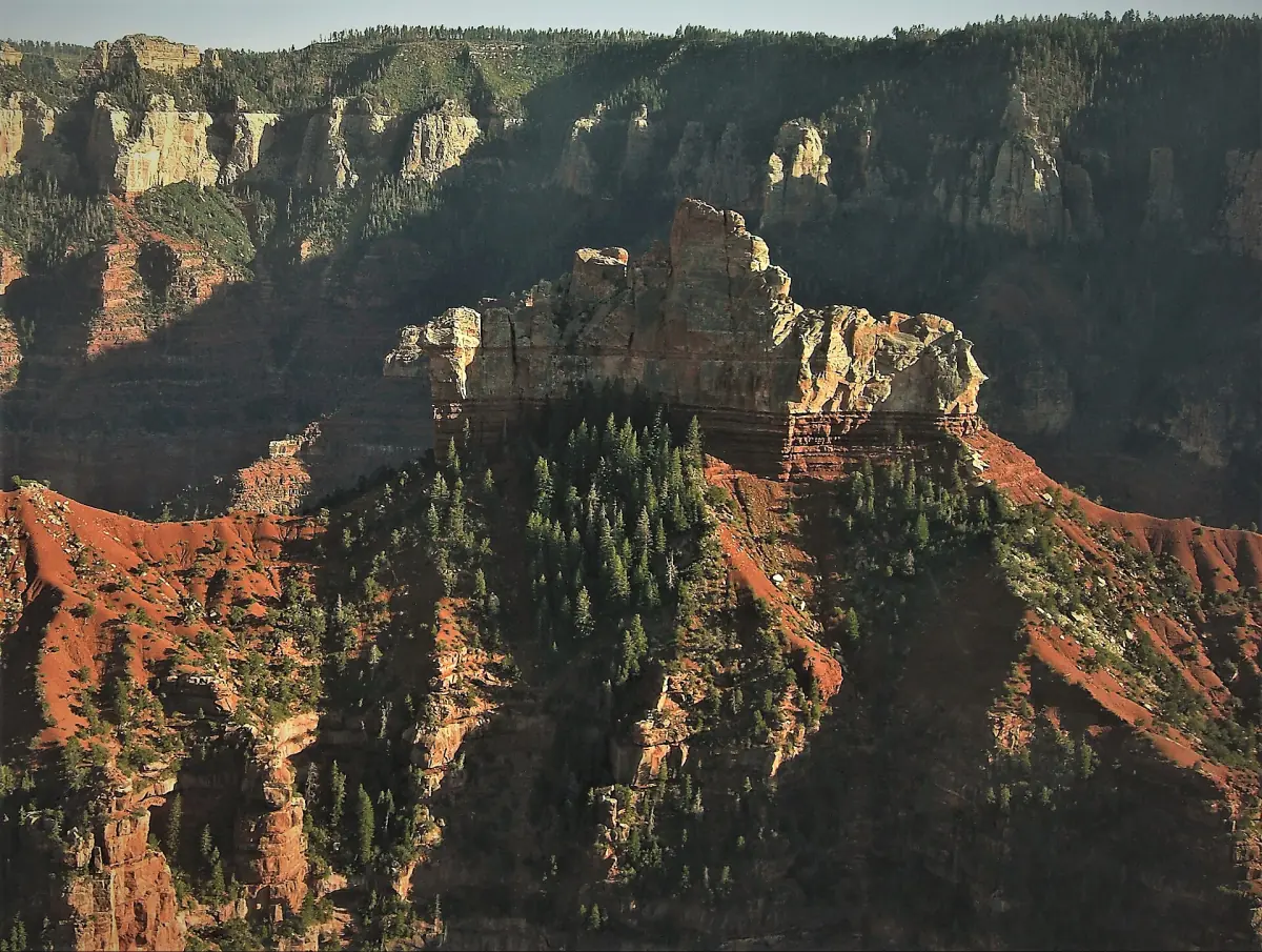 Aerial view of a rocky peak and red slopes in the canyon