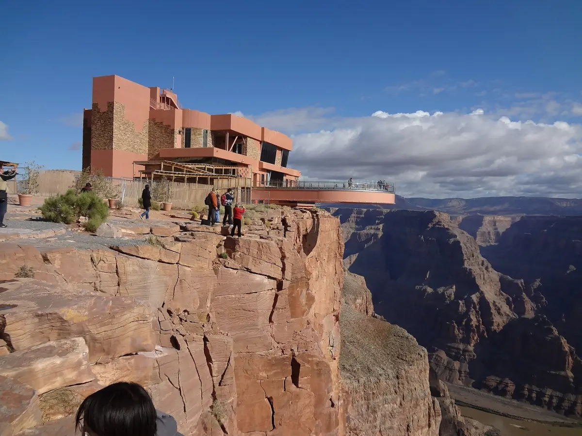Skywalk visitor building on the canyon rim at Eagle Point under scattered clouds
